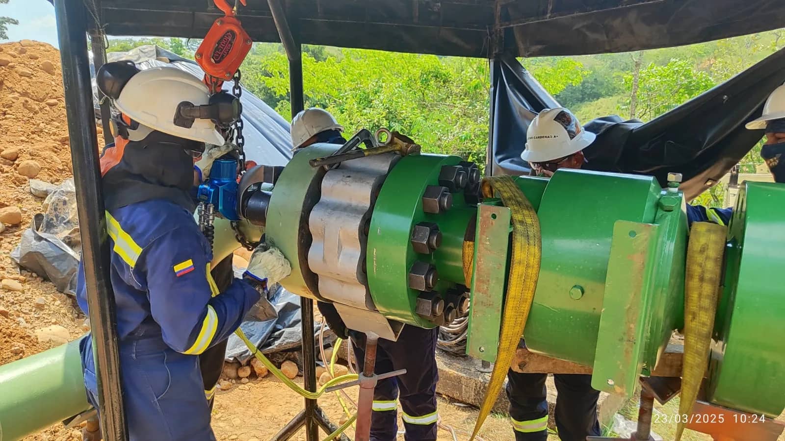 Cuadrilla de Ingeniería STM instalando y ajustando una válvula de gran diámetro en una línea de tubería con aparejo de izaje, en campo.